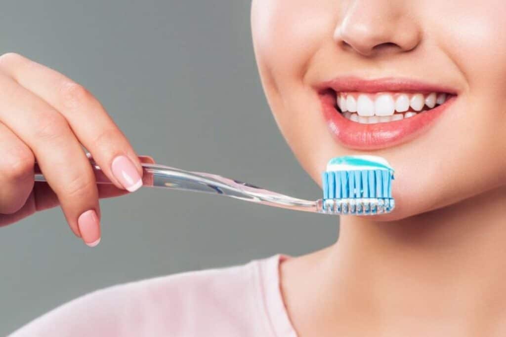 Face of smiling women with tooth brush in hand